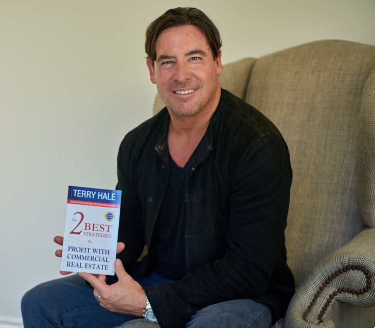 Terry Hale holding his book, The 2 Best Strategies to Profit With Commercial Real Estate